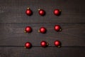 Dark rustic wood table flatlay - Christmas background with red christmas ornaments. Top view with free space for copy text Royalty Free Stock Photo