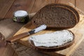 Dark rye bread, sandwich and knife on wooden cutting board and salt in saltshaker on burlap Royalty Free Stock Photo