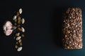 Dark rye, cereal bread with sunflower seeds, whole bread, wheat stems, pumpkin seeds, nuts, garlic on a dark background shale boar Royalty Free Stock Photo