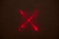 On a dark, semi-blurred background, a crossed red beam of light Royalty Free Stock Photo