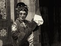 Dark sepia version of an elderly Chinese Teochew opera singer perform