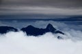 Dark sharp peaks rise above the clouds in Carnic Alps Italy