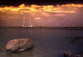 Dark shot nit dramatic sky of a lake with a long jetty and a ship in the background