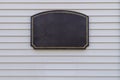 Dark sign board frame for address on siding planks background