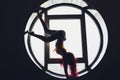 The dark silhouette of a beautiful woman on the background of the round window. yoga, acrobatics. Royalty Free Stock Photo