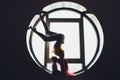 The dark silhouette of a beautiful woman with child on the background of the round window. yoga, acrobatics. Royalty Free Stock Photo