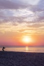 Dark silhouette of a child playing on the beach by sunset. Sea and pastel colours of sky and clouds. Magical sea landscape. Summer Royalty Free Stock Photo