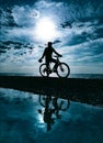 silhouette of a guy on a mountain bike against the background of the sea and beautiful textures of clouds Royalty Free Stock Photo