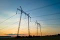 Dark silhouette of high voltage towers with electric power lines at sunrise Royalty Free Stock Photo