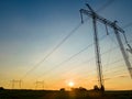 Dark silhouette of high voltage towers with electric power lines at sunrise Royalty Free Stock Photo