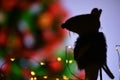 Dark silhouette of a rat on a background of abstract decorated Christmas tree.