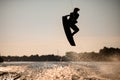 dark silhouette of wakeboarder athlete man jumping high making tricks in the air Royalty Free Stock Photo