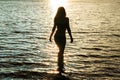 Dark silhouette woman at sunset in water