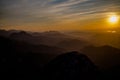 Dark silhouettes of the Carpathian rocky mountains and sunset sky with a large yellow sun