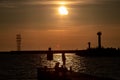 Dark silhouettes of fishermen on the pier at sunset. Royalty Free Stock Photo