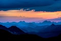 Dark silhouettes of mountains against the sky at sunset with dark clouds Royalty Free Stock Photo