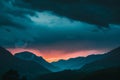 Dark silhouettes of mountains against the sky at sunset with dark clouds Royalty Free Stock Photo