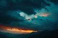 Dark silhouettes of mountains against the sky at sunset with dark clouds Royalty Free Stock Photo