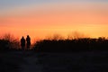 dark silhouettes of 2 people watch the orange sunset on the beach of RÃ¼gen on the Baltic Sea. Royalty Free Stock Photo