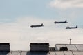 Dark silhouettes of three Russian military aircraft flying low over the roofs