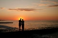 dark silhouettes of young people on the background of the sunset on the sea Royalty Free Stock Photo