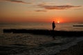 dark silhouettes of young people on the background of the sunset on the sea