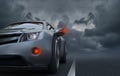 Passenger car rides on an asphalt road amid thunderclouds