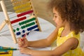 A dark-skinned African-American girl is ready for a math and arithmetic lesson with an abacus Royalty Free Stock Photo