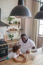 Dark-skinned bearded man putting coins into the moneybank and smiling Royalty Free Stock Photo