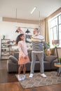 Dark-skinned girl with pony tails dancing with her bearded grandfather