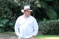 Dark-skinned Latino 50 year old man dressed in guayabera and hat, traditional Latin American dress, enjoys a walk outdoors