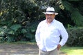 Dark-skinned Latino 50 year old man dressed in guayabera and hat, traditional Latin American dress, enjoys a walk outdoors