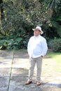 Dark-skinned Latino 50 year old man dressed in guayabera and hat, traditional Latin American dress, enjoys a walk outdoors