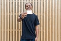 Dark-skinned man in black T-shirt showing blank business card to camera. Royalty Free Stock Photo