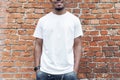 Dark-skinned man showing blank business card on red bricked background. Royalty Free Stock Photo