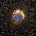 Dark sky ball in middle of swirling stone seashore. Inversion of tiny planet transformation of spherical panorama 360 degrees. Royalty Free Stock Photo