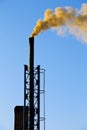 Dark smoke from a chimney against blue sky Royalty Free Stock Photo