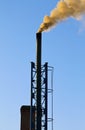 Dark smoke from a chimney against blue sky Royalty Free Stock Photo