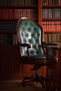 Dark solid interior of old library with many books on the wooden shelves. Vintage classic chair from green leather and red wood, a Royalty Free Stock Photo