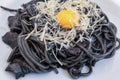 dark spaghetti pasta with egg and cheese on a white plate Royalty Free Stock Photo