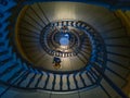 Dark spiral staircase with people walking around