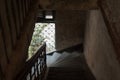 Dark stair descent in old house with natural light coming from a barred window. The Mansion or Villa Bodega, Phnom Penh, Cambodia Royalty Free Stock Photo