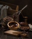 Dark still life with melted chocolate in wooden bowl Royalty Free Stock Photo