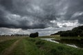 Dark storm clouds above a pond between fields at the forest in bohemia Royalty Free Stock Photo