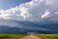 Dark storm clouds approaching a straight road Royalty Free Stock Photo