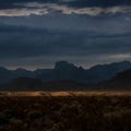 Dark Storm Clouds Gather Over Chisos Mountains With Sliver Of Sun Light In The Valley Royalty Free Stock Photo