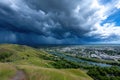 Dark storm clouds gather over a river valley town Royalty Free Stock Photo