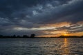 Dark storm clouds over the lake and sunset Royalty Free Stock Photo