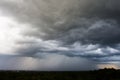 Dark storm clouds over meadow with green grass. Royalty Free Stock Photo