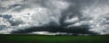 Dark storm clouds panorama above the green grass field Royalty Free Stock Photo
